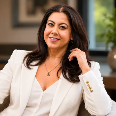 Pooja Lal, co-founder of P&J PitchWorks Co., smiling in a white blazer